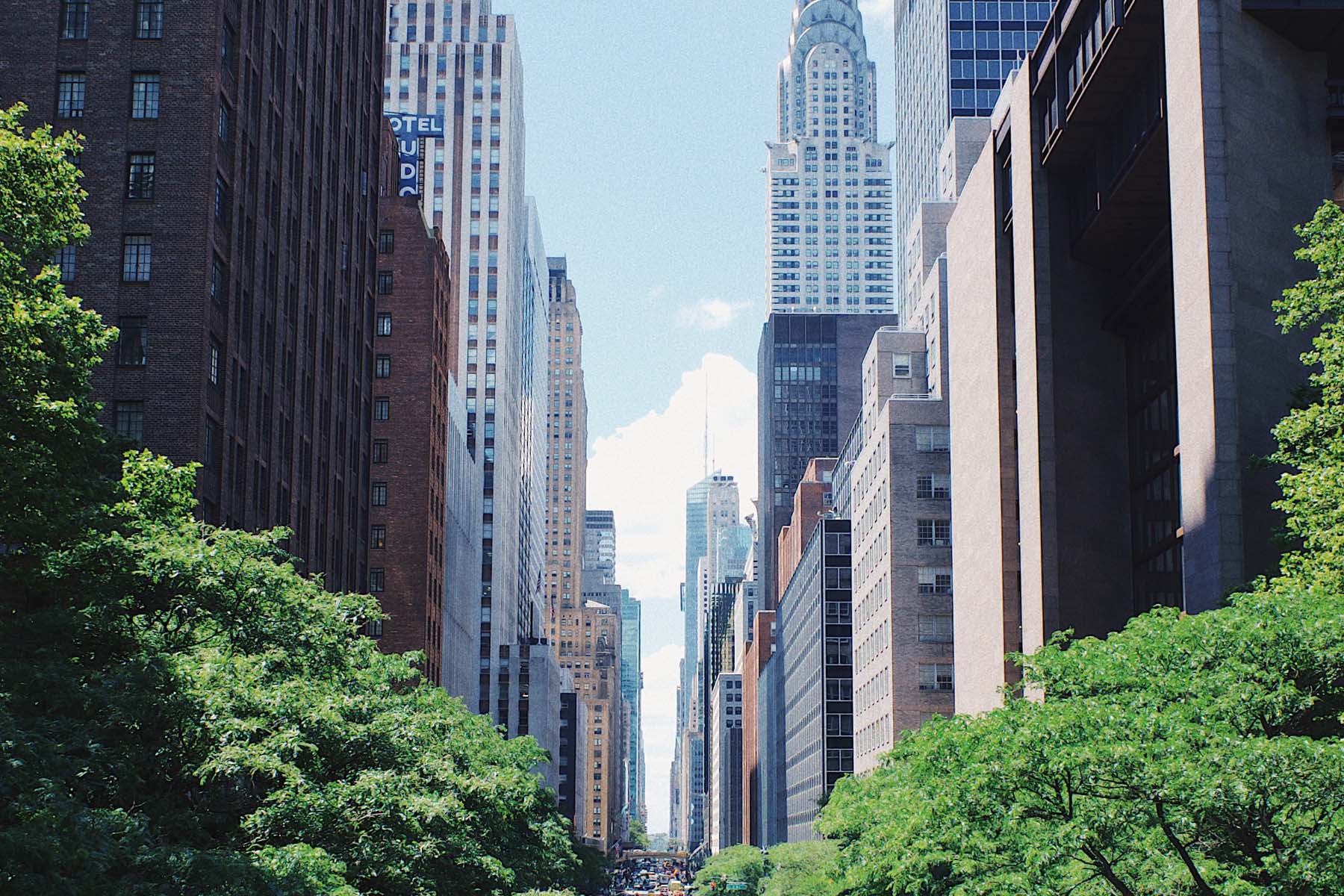 Looking down a city street with skyscrapers lining the street
