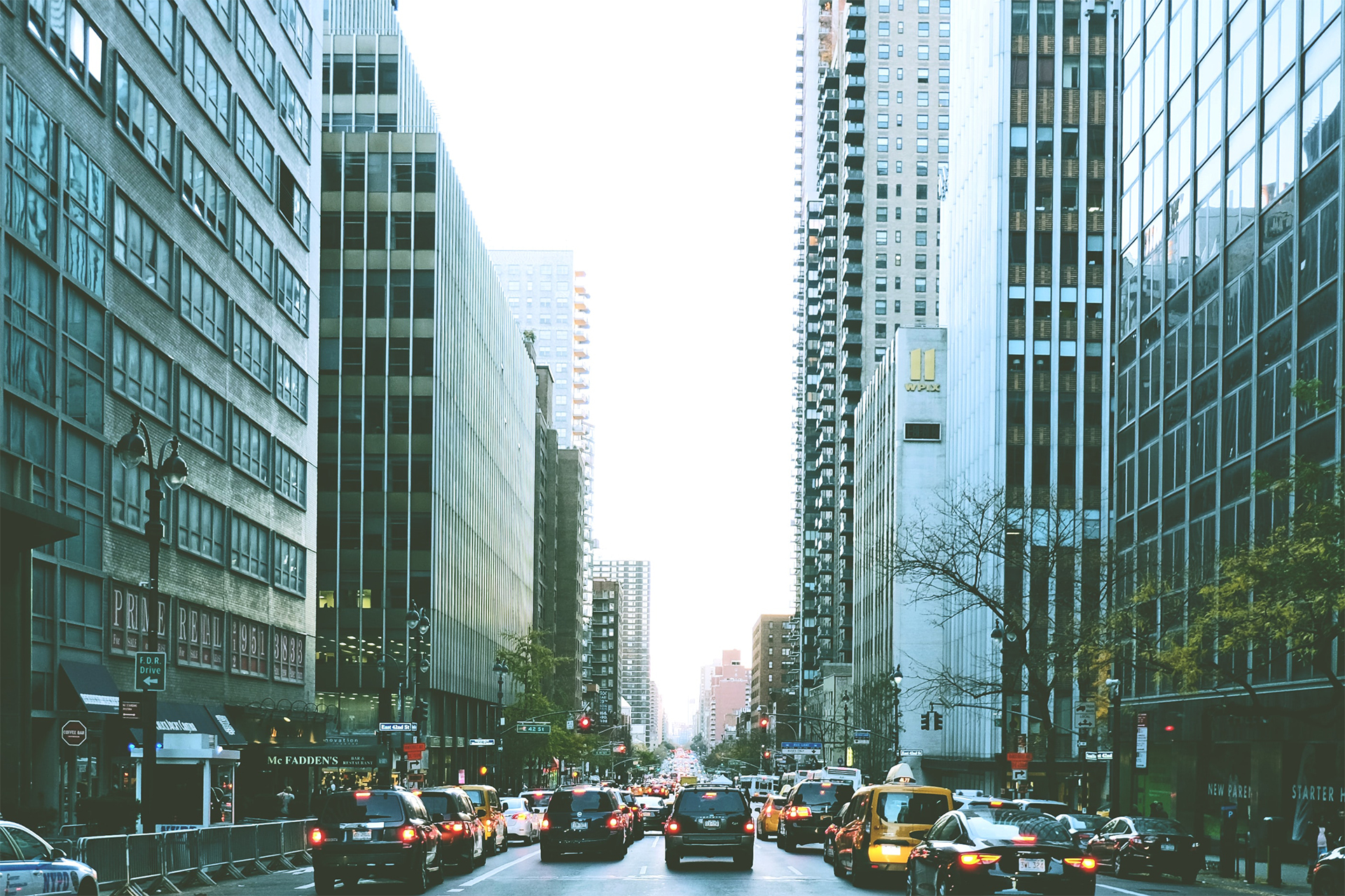 looking down a city street with skyscrapers lining the street
